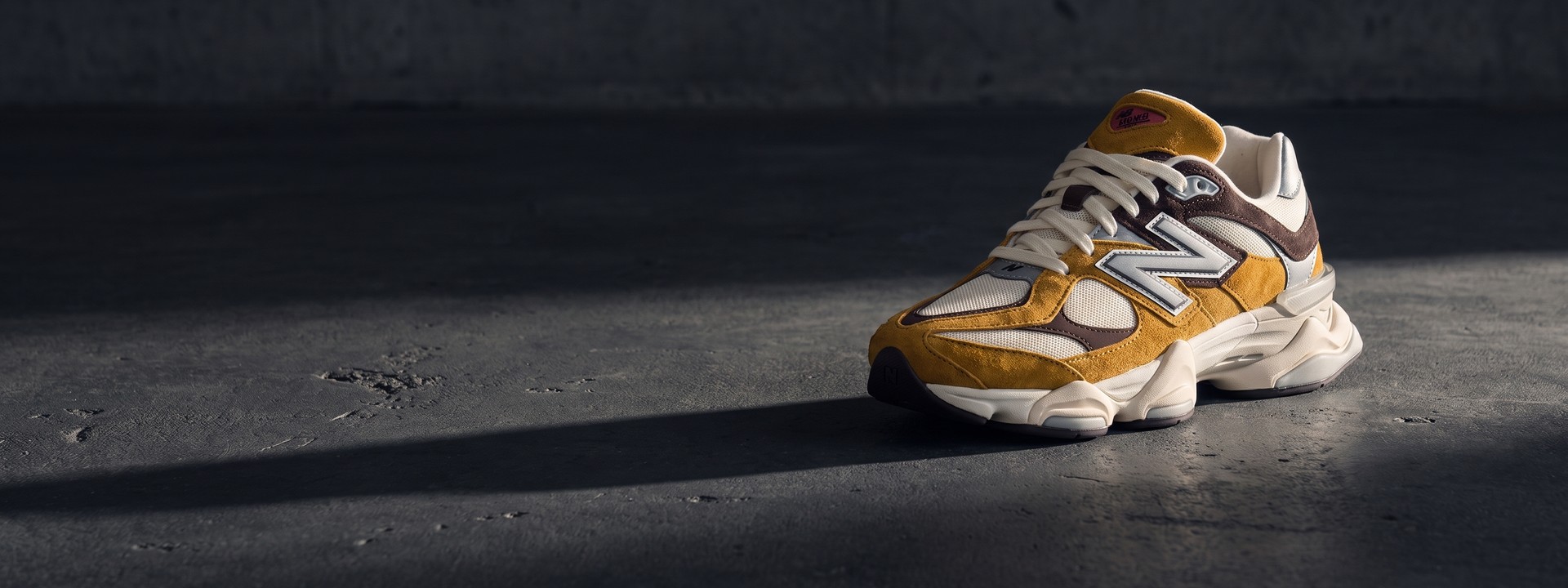 Кроссовок New Balance 9060 на тёмном бетонном полу